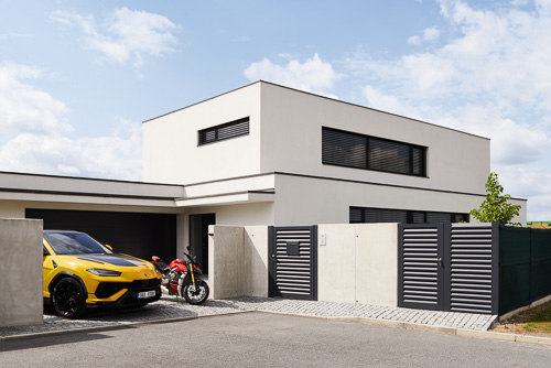 Architektura rodinného domu u Prahy od stavební firmy Simple Progress s motorkou a Lamborghini Urus